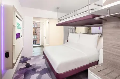 a bedroom with a large white bed in a room at YOTEL Glasgow in Glasgow