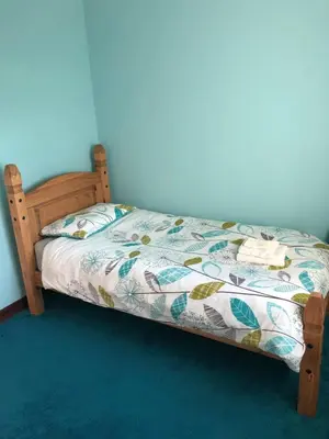 a bedroom with a bed with a comforter on it at Inveroran in Campbeltown