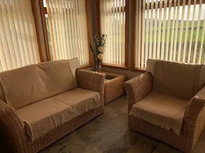 two chairs and a couch in a room with windows at Inveroran in Campbeltown