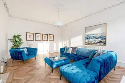 a living room with a blue couch and chairs at Heart of Edinburgh City Centre 3 Bed Georgian Apt in Edinburgh