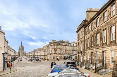 a city street with cars parked in front of buildings at Heart of Edinburgh City Centre 3 Bed Georgian Apt in Edinburgh