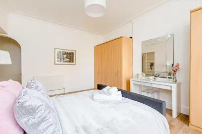 a bedroom with a white bed and a sink at Heart of Edinburgh City Centre 3 Bed Georgian Apt in Edinburgh