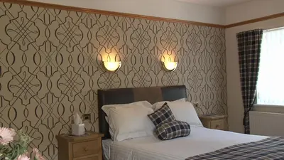 a bedroom with a bed and two lights on the wall at Highland Getaway in Kinlochleven