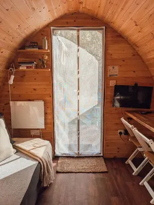 a room with a large window in a wooden house at Strathyre Camping Pods in Strathyre