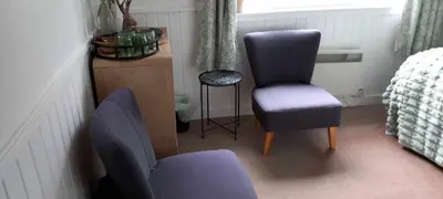 a room with two chairs and a chair and a table at Don Muir Guesthouse in Oban