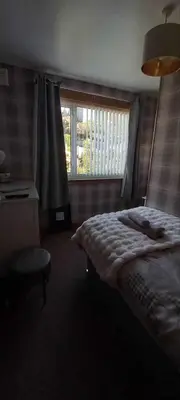 a bedroom with a bed and a window at Don Muir Guesthouse in Oban