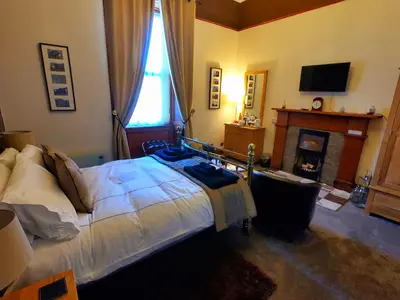 a bedroom with a bed with a fireplace and a television at Gowanlea Heights in Campbeltown