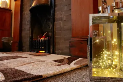 a room with a bed and a fireplace with christmas lights at Gowanlea Heights in Campbeltown