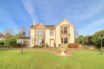 a large house with a fountain in the yard at Duneira House in Helensburgh