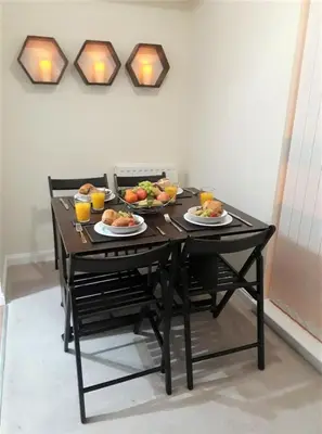 a black table with plates of food on it at Airdrie Apartments in Airdrie
