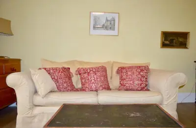 a white couch with four red pillows on it at Thistle Street Apartment at Heart of the City Centre in Edinburgh