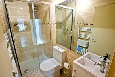 a bathroom with a shower and a toilet and a sink at Thistle Street Apartment at Heart of the City Centre in Edinburgh