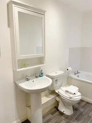 a bathroom with a sink and a toilet and a mirror at Cozy Nights - Cambuslang 1/64 in Glasgow
