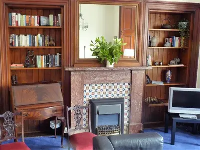 a living room with a fireplace and a tv at Kinneil Self Catering in Lamlash