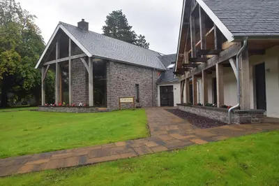 a house with a grass yard next to a building at The Loch Lomond Guesthouse in Balloch
