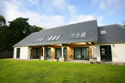 a house with a gambrel roof and a lawn at The Loch Lomond Guesthouse in Balloch