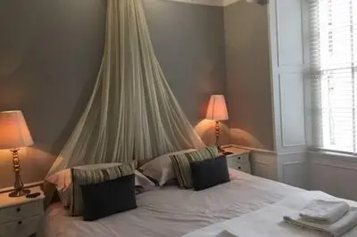 a bedroom with a white bed with two lamps at castle Apartment 1 in Edinburgh