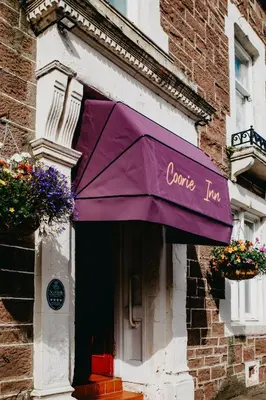 a purple umbrella on the side of a building at Coorie Inn Restaurant and Rooms in Crieff