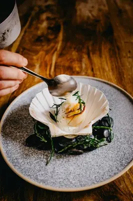 a person eating a plate of food with a spoon at Coorie Inn Restaurant and Rooms in Crieff