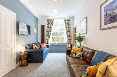 a living room with a couch and a window at Grassmarket Jewel in Edinburgh