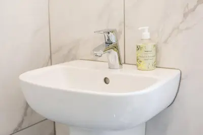 a white bathroom sink with a soap bottle on it at Grassmarket Jewel in Edinburgh