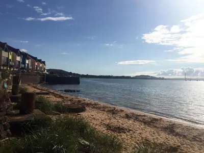 a beach with a body of water and some houses at Beach House No1 With Amazing Sea Views And Direct Beach Access in Fairlie