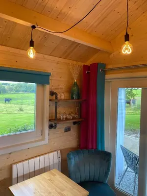 a dining room with a table and a window at Dunroamin Lodges in Drymen