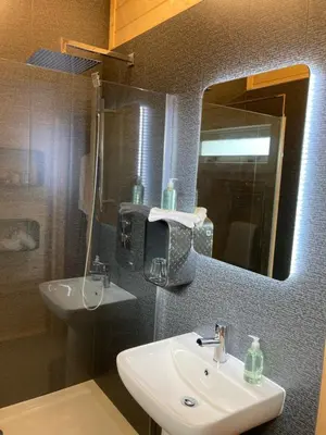 a bathroom with a sink and a mirror at Dunroamin Lodges in Drymen