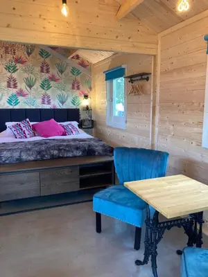 a bedroom with a bed and a table and chairs at Dunroamin Lodges in Drymen