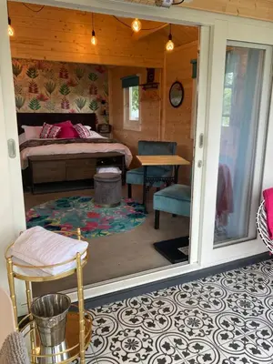 a bedroom with a bed and a table and chairs at Dunroamin Lodges in Drymen