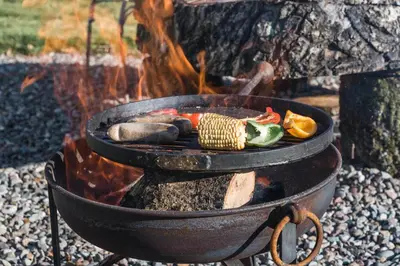 a grill with a bunch of food in front of a fire at Dunroamin Lodges in Drymen