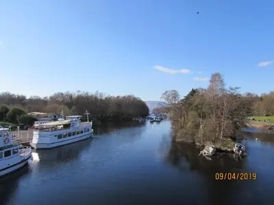 two boats are docked on a river at Levenhowe Holiday Apartment in Balloch