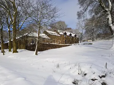 a snow covered yard with a building in the background at B&B Drum Farm in Stirling