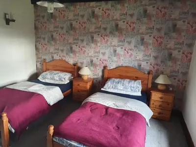 two beds in a room with a wall with hearts at B&B Drum Farm in Stirling