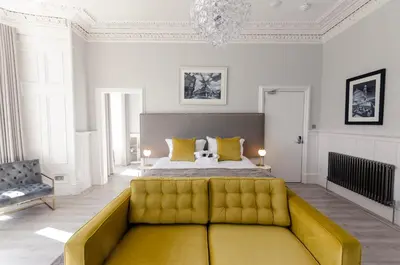 a bedroom with a bed and a yellow couch at Sweeney Motherwell in Motherwell