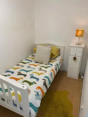 a bedroom with a white bed with a bedskirtspectspectspectspects at Fab-u-Luss in Luss
