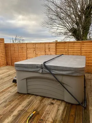 a mattress sitting on a deck with a fence at COACHMAN COTTAGE OUTSIDE HOT TUB in Beith