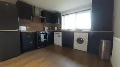 a kitchen with a washing machine and a window at Carvetii - Clark House - Spacious ground floor flat in Rosyth