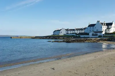 a group of white houses on the shore of a beach at Killinallan Cottage in Port Charlotte