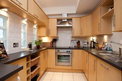 a kitchen with wooden cabinets and a stove top oven at Saligo in Port Charlotte