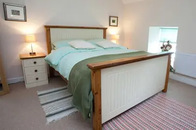 a bedroom with a large bed with a wooden frame at Saligo in Port Charlotte