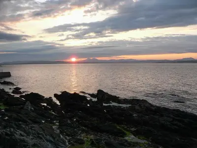 a sunset over a large body of water at Kilchoman in Port Charlotte