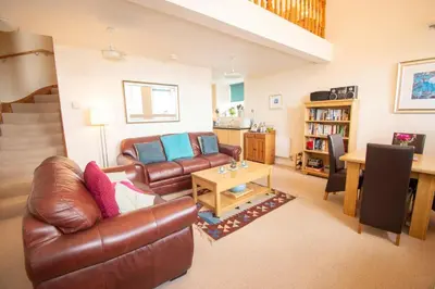 a living room with a leather couch and a table at Kilchoman in Port Charlotte