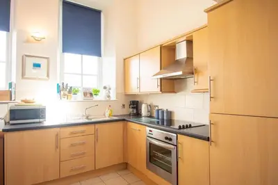 a kitchen with wooden cabinets and a stove top oven at Ardnave in Port Charlotte