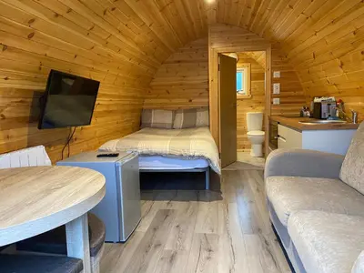 a small room with a bed in a wooden cabin at Tarbert Holiday Park in Tarbert