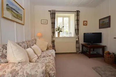 a living room with a couch and a television at Darroch Beag in Saint Catherines
