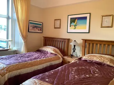 a bedroom with two beds and a window at Struan House B&B in Tarbert