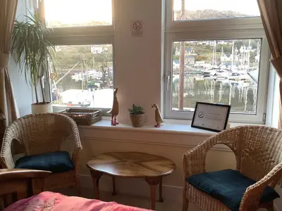 a room with two chairs and a table and a window at Struan House B&B in Tarbert
