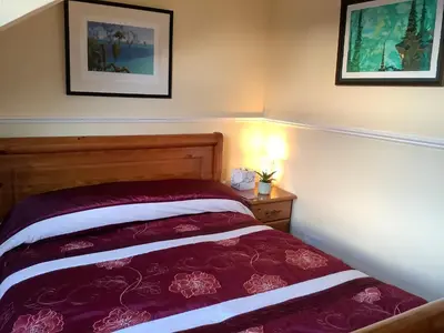a bedroom with a bed and two pictures on the wall at Struan House B&B in Tarbert