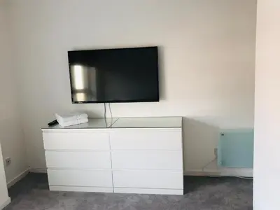 a flat screen tv on top of a white dresser at Modern 2 bedroom Apartment Near City Centre in Glasgow